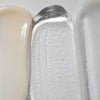 Una imagen en primer plano muestra las texturas de Solawaves LightBoost Wand Activating Serum, con beige cremoso, gel transparente con tecnología LightBoost y crema suave gris claro/blanco. Las texturas varían de cremosa a gelatinosa, cada una de ellas con un acabado brillante.